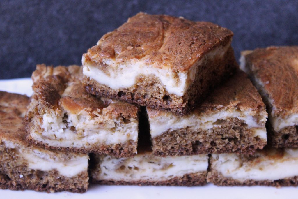 Gingerbread Cheesecake Brownies stacked on a platter