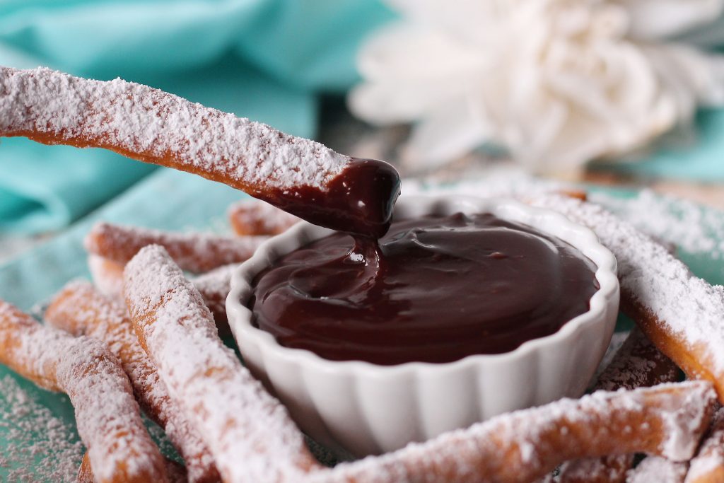 Beignet Fry being dipped in Chocolate sauce