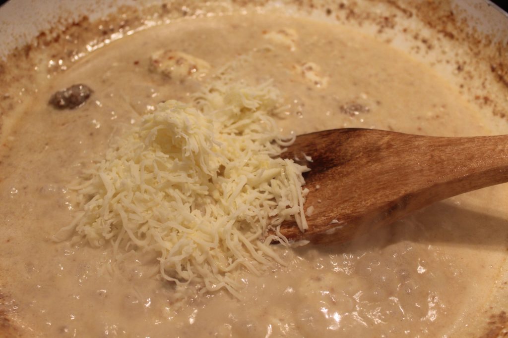 adding cheese to creamy broth