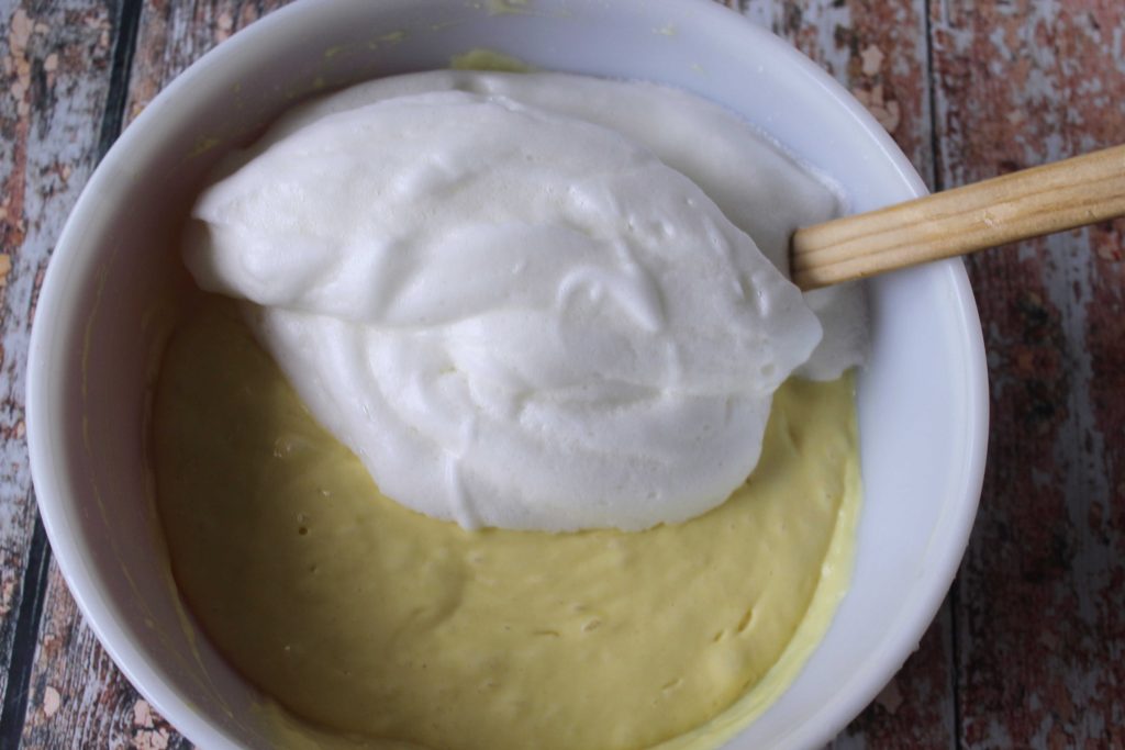 Whipped eggs whites being mix in lemon cupcake batter