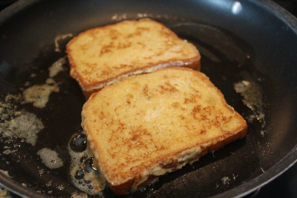 Eggnog French toast cooking in a pan