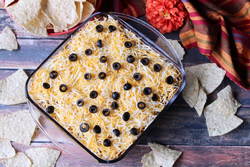 Tex Mex Layered Dip surrounded by tortilla chips 