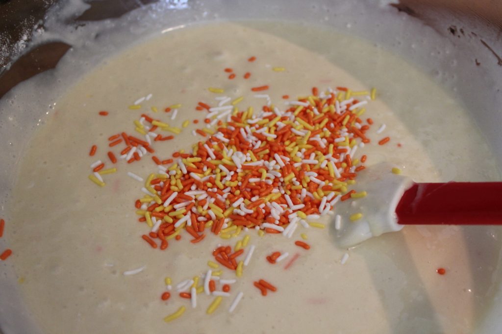 adding candy corn sprinkles to cake batter