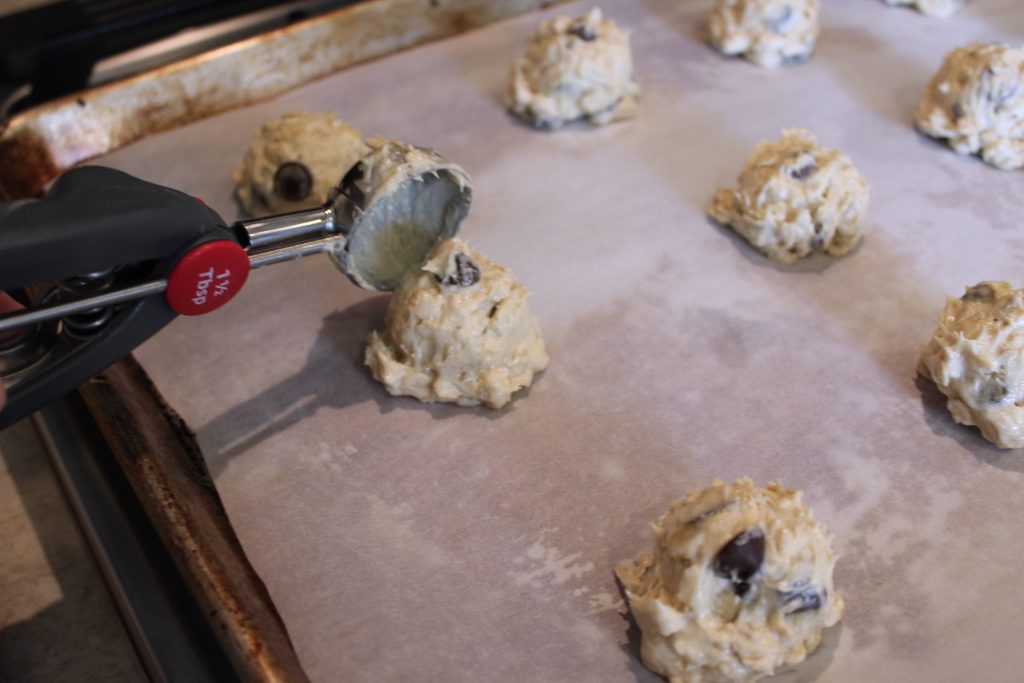 cookie dough being scooped on a cookie tray