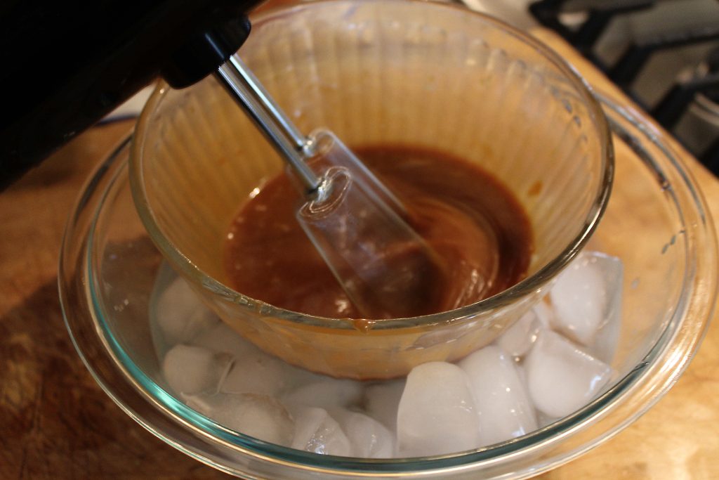 whipping caramel over a ice water bath