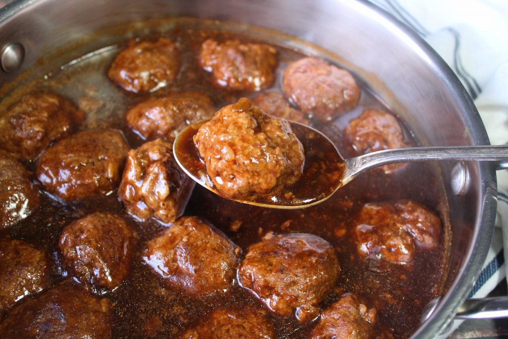 Meatballs and Brown gravy with a meatball on a spoon