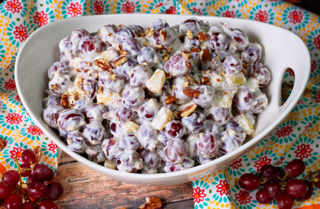 Grape Salad in a white bowl garnished with pecans