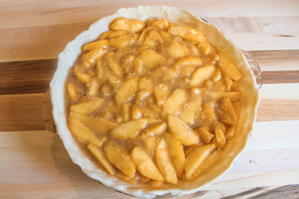 Fresh peach pie filling in the bottom crust