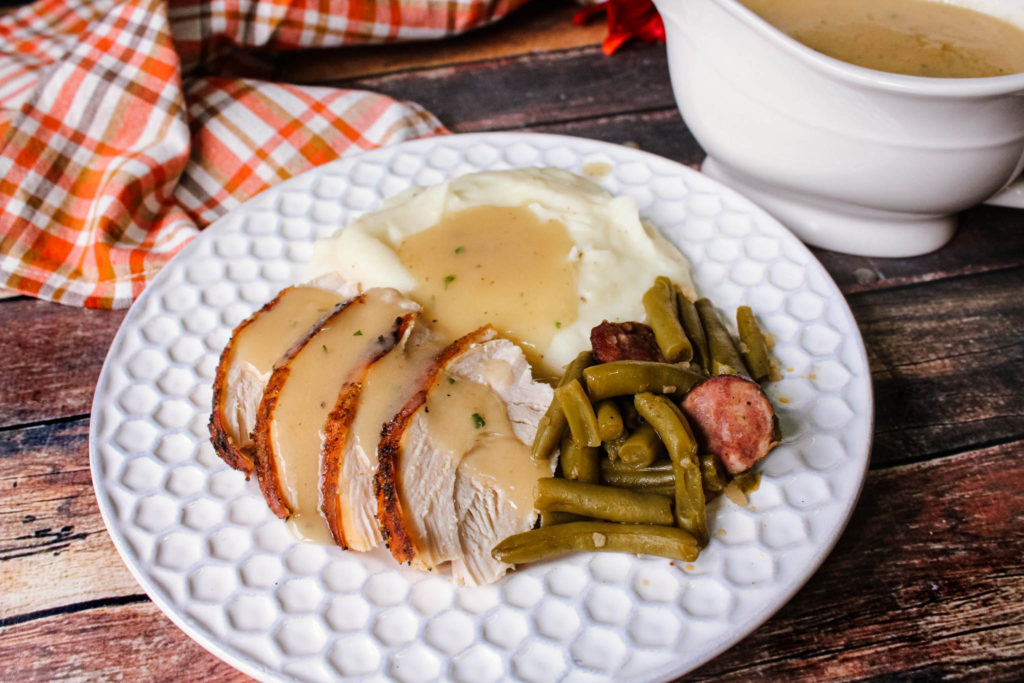 Old Fashioned Turkey gravy poured over turkey and potatoes