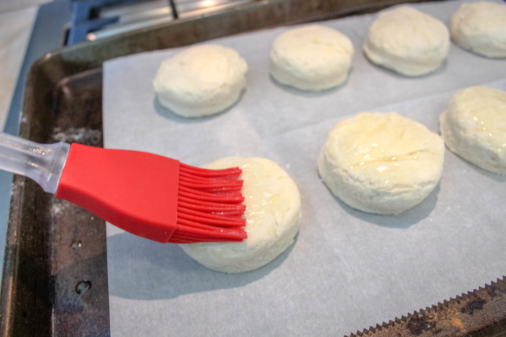 Biscuits before baking being brushed with butter