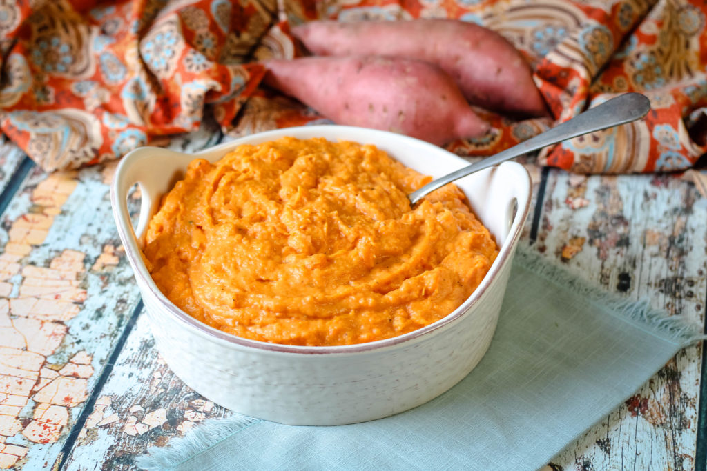 Creamy Mashed Sweet Potatoes in a serving bowl and spoon