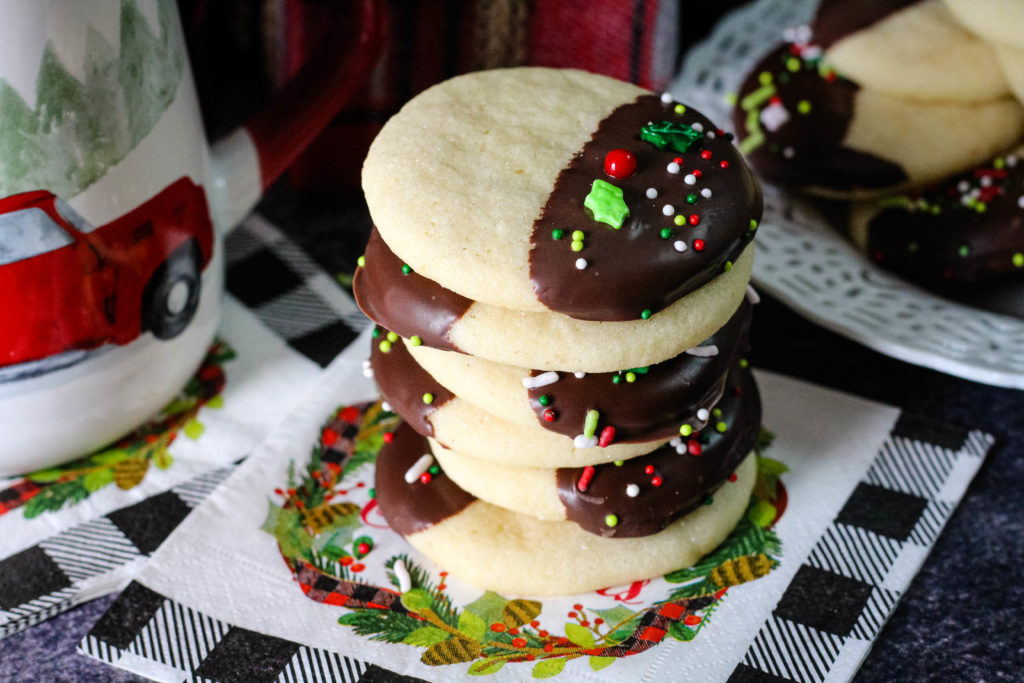 Chocolate Dipped Sugar Cookies stacked on a Christmas Napkin