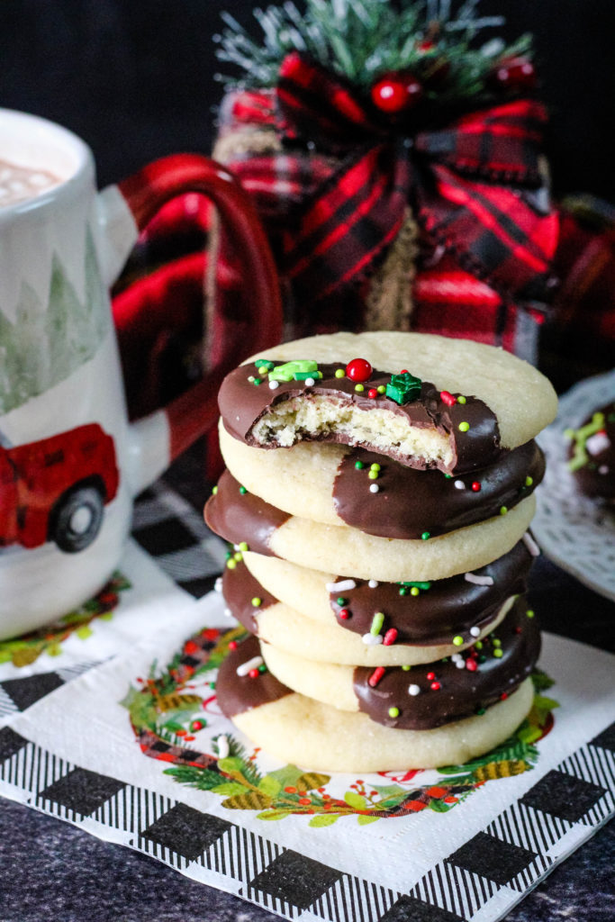 Chocolate dipped sugar cookies stacked with a bite taken from one