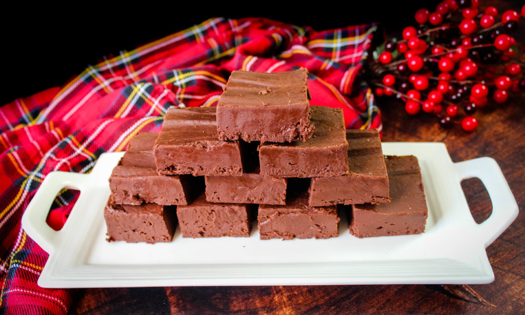Fudge sliced in squares on a white serving dish