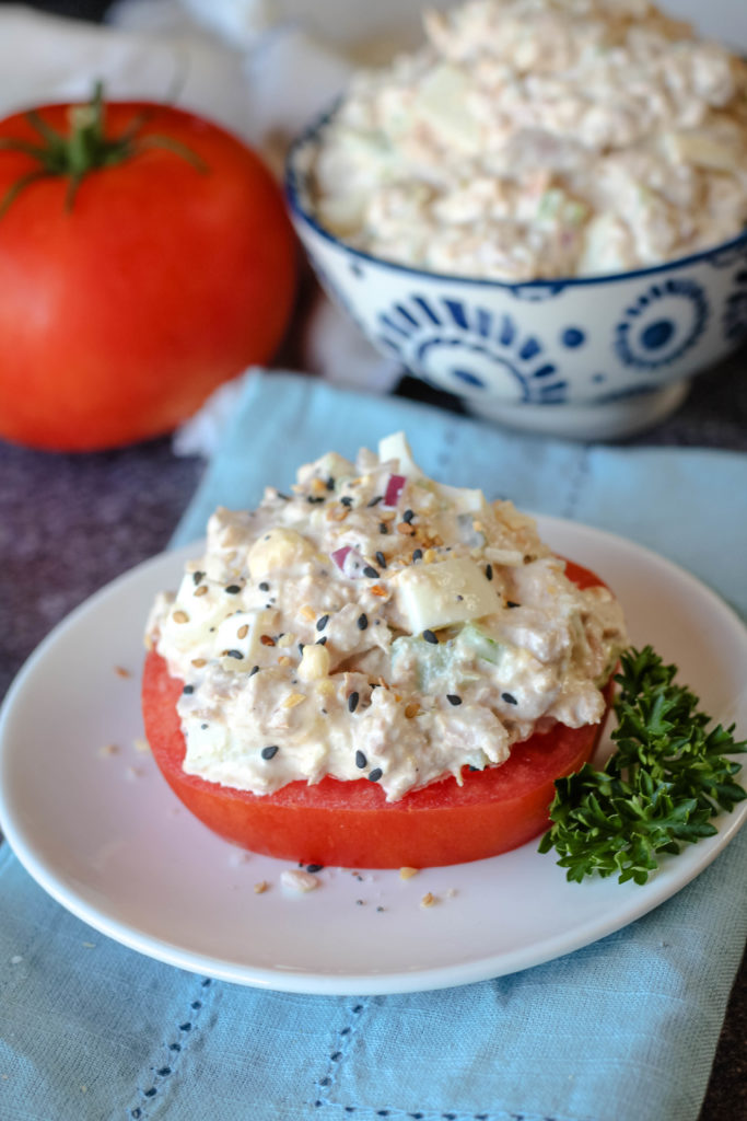 Classic Tuna salad served on a tomato slice on a white plate