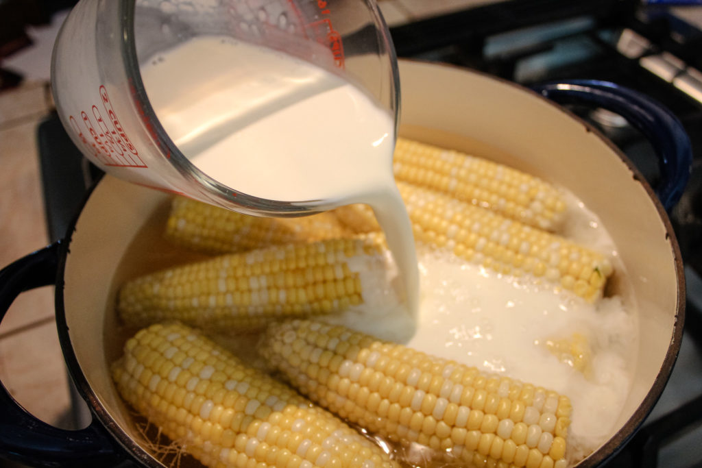 Pouring milk into a pot with corn