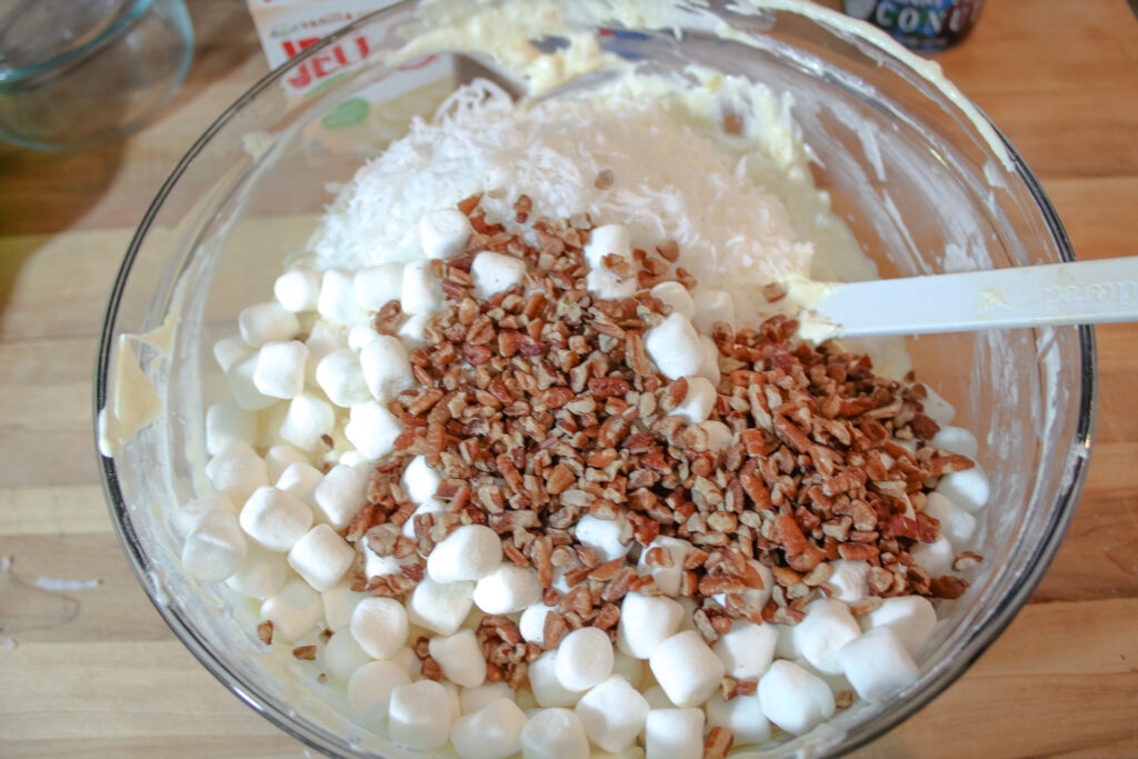 Marshmallow , pecans , and shredded coconut added to the mixture