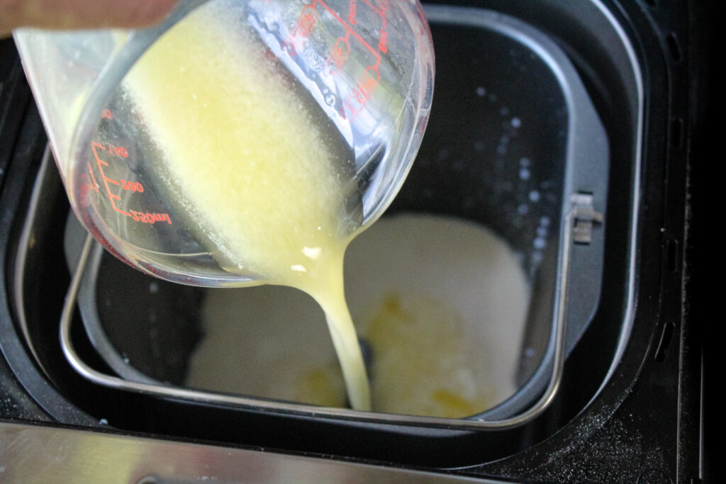 Pouring melted butter into the bread machine