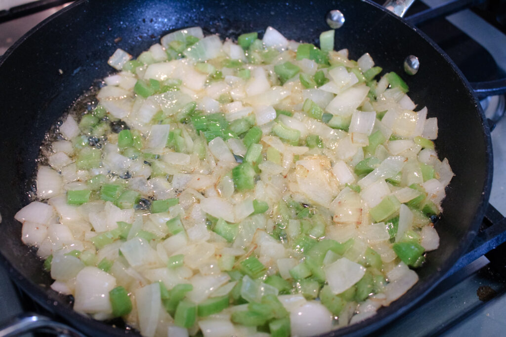 onions and celery cooked in a skillet.