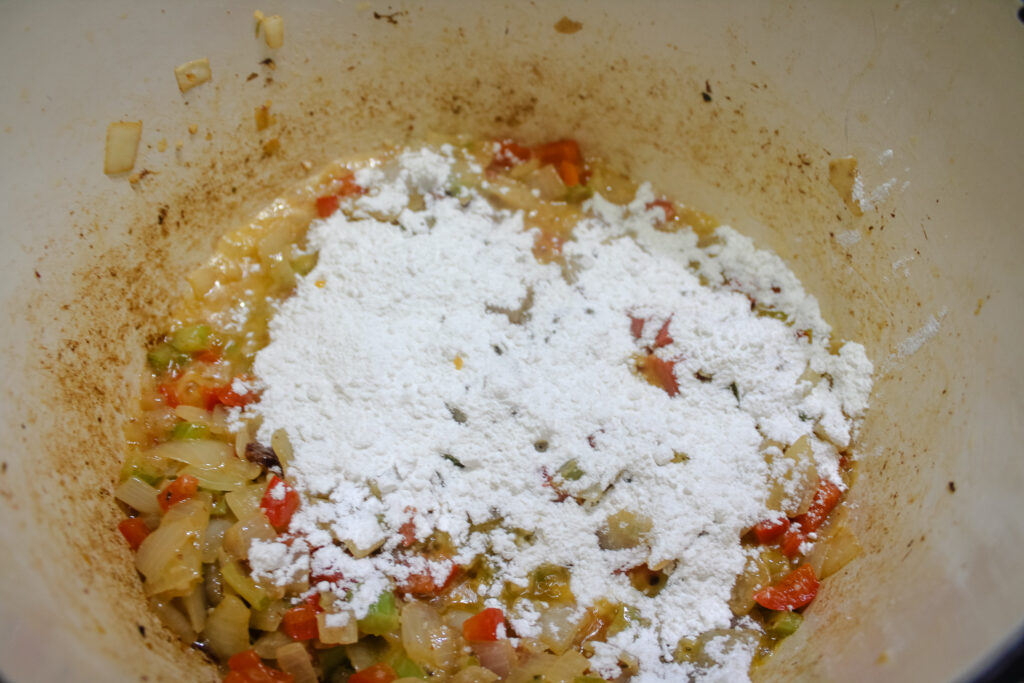 Adding the flour to the butter and veggies to make a roux. 