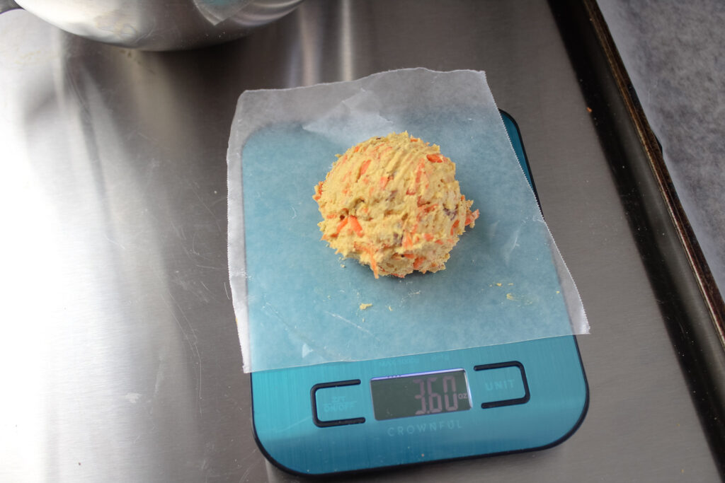 Crumbl Carrot Cake Cookies dough ball being weighed on a kitchen scale