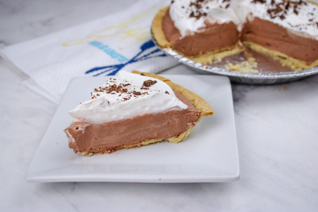 A slice of easy chocolate cream pie on a white plate 
