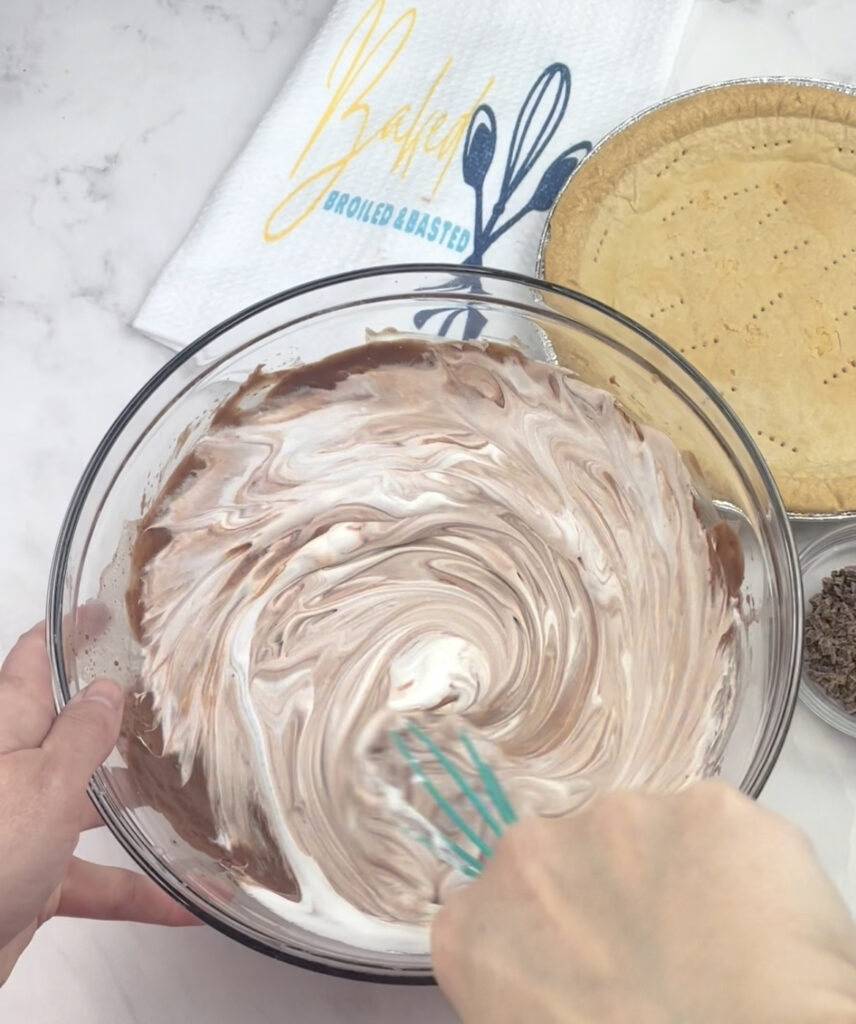 Whipped topping being mixed with chocolate pudding 