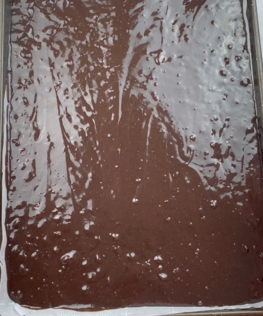 The brownie batter spread on a jelly roll pan to make Patriotic Star Brownies