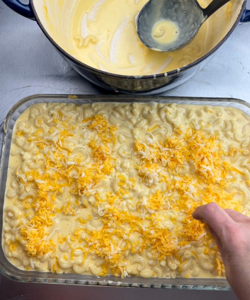Adding cheese to the top of old fashioned macaroni and cheese. 