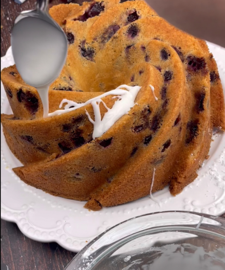 Cherry Amaretto Bundt Cake baked with glaze being drizzled 