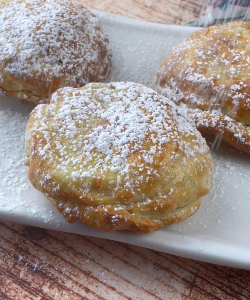 Mini Monte Cristo Sandwiches being dusted with powdered sugar