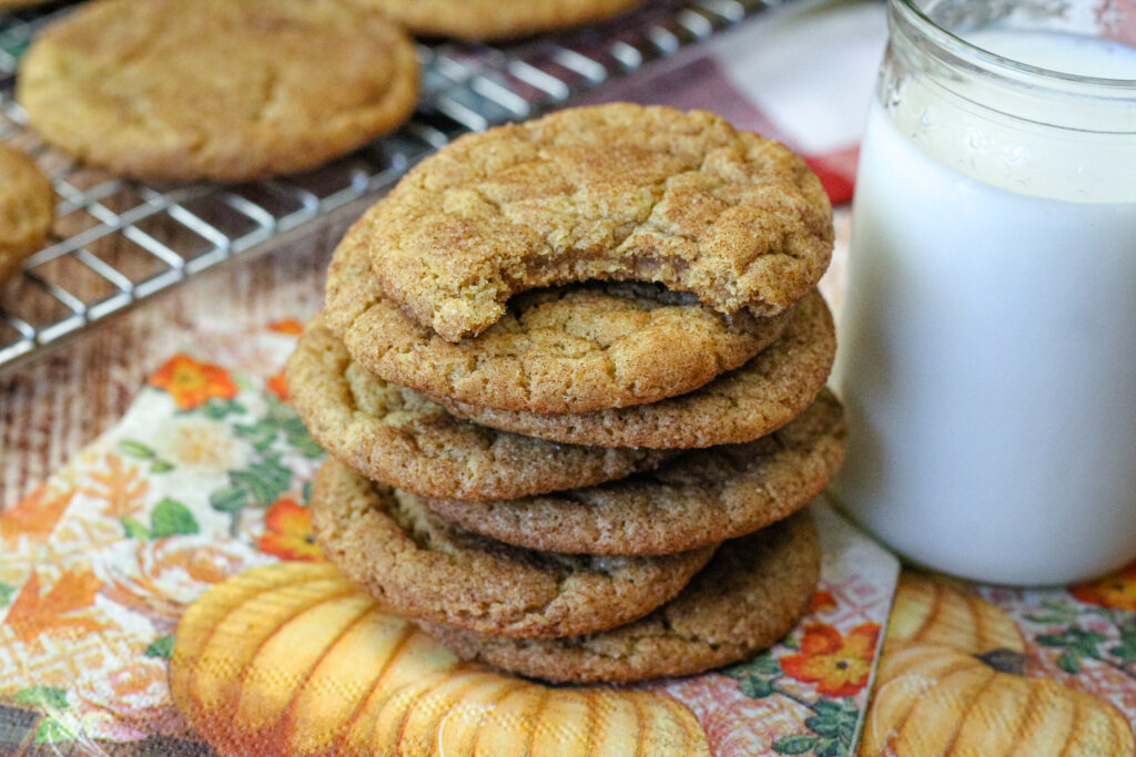 A stack of pumpkin snickerdoodles with the top cookie bitten 