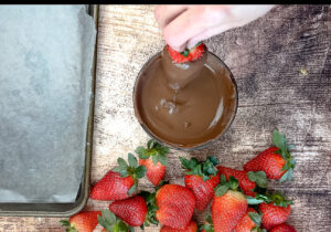 dipping a strawberry in chocolate