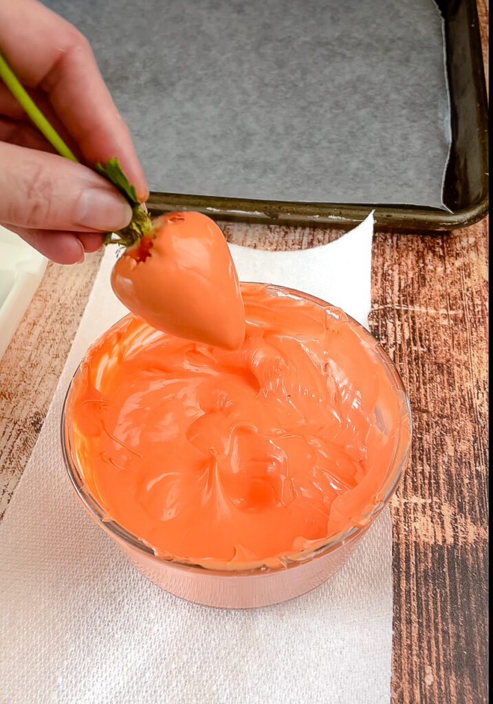 Showing the fresh strawberry dipped in orange candy melts 