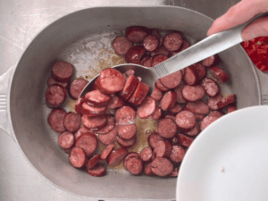 Removing sausage from a dutch oven with a slotted spoon
