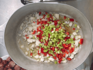 Onions , red bell pepper , and celery browning in a dutch oven