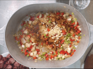 Adding cajun seasoning and garlic to the pot for Cajun sausage potato soup