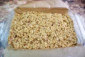 Cookie Butter Rice Krispie treats pressed into a prepared 9x13 glass dish