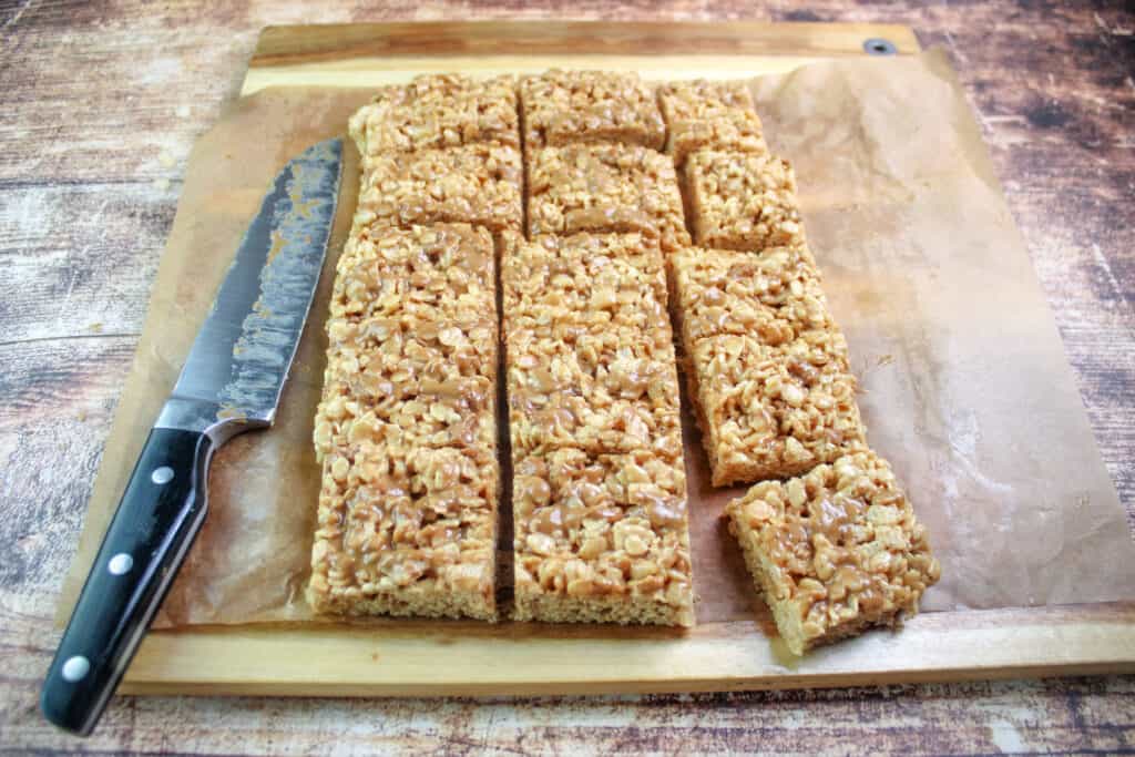 Cookie Butter Rice Krispie treats lifted out of the pan and cut into 15 pieces