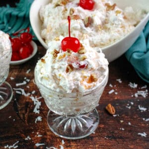 Southern ambrosia salad in a small glass serving cup and with a cherry on top