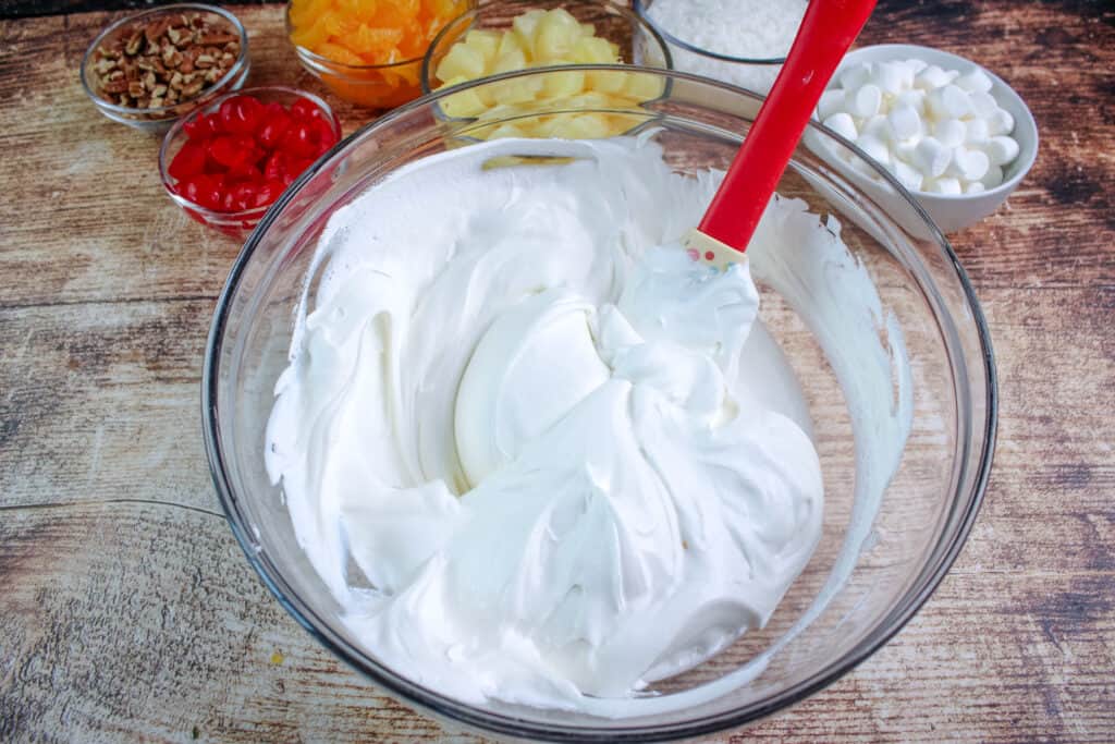 In a large bowl the cool whip and sour cream mixed together