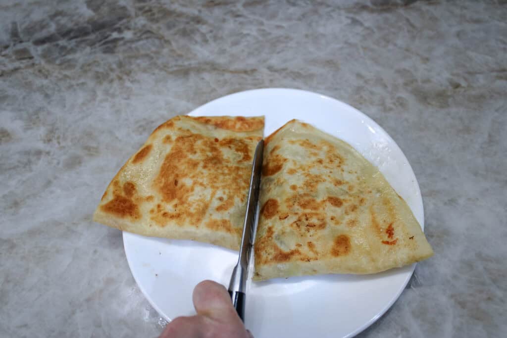 Cutting a leftover steak quesadilla in half