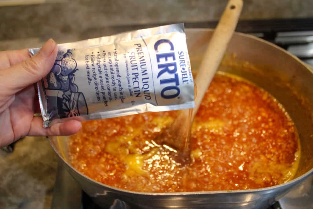 Adding the liquid pectin to the peach mixture for Peach Jam