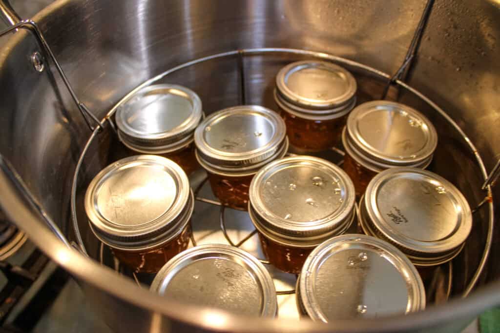 Sterilizing the peach pepper jam in a hot water bath 