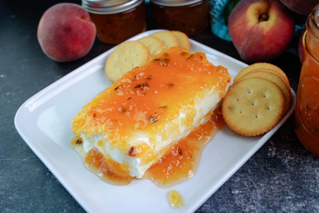 Serving peach pepper jam over cream cheese with crackers 