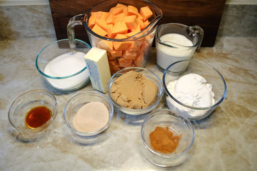 The ingredients for Easy Sweet potato cobbler . Cubed sweet potatoes, brown and white sugar, self rising flour vanilla , butter and cinnamon . 