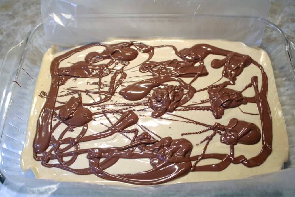 Melted chocolate pour over peanut base for Tiger Butter 