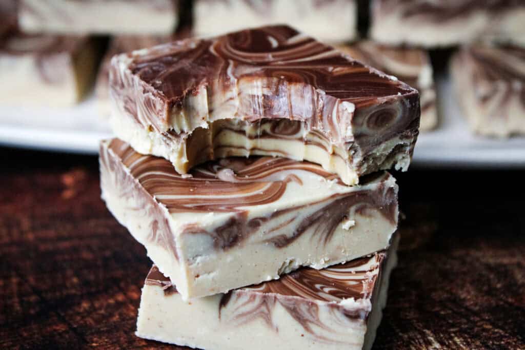 A stack of tiger butter with a bite taken out of the top piece . 