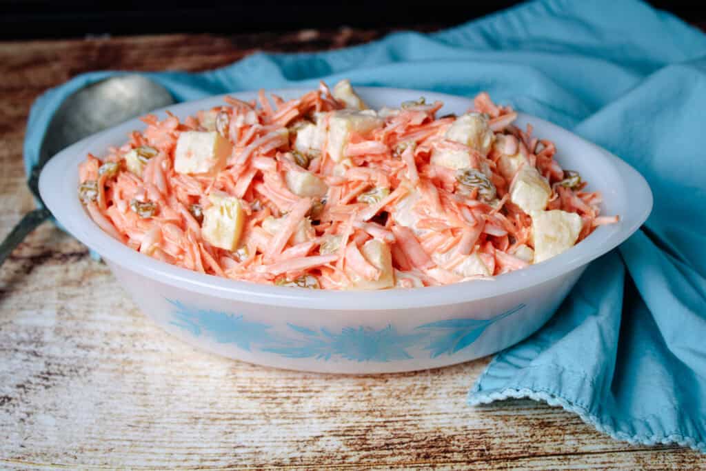 The old fashioned carrot salad in a vintage white serving dish with blue floral print 