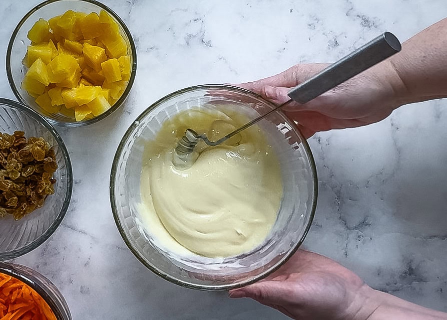 The dressing mixed together in a bowl wit a whisk in it 